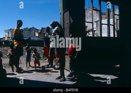 Profughi rifugiatisi in guerra gli edifici danneggiati in Angola. Foto Stock