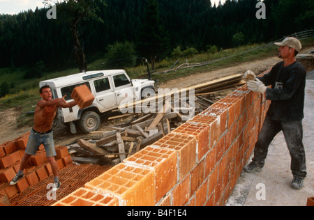 Lavoratori brickwall edificio, Kosovo Foto Stock