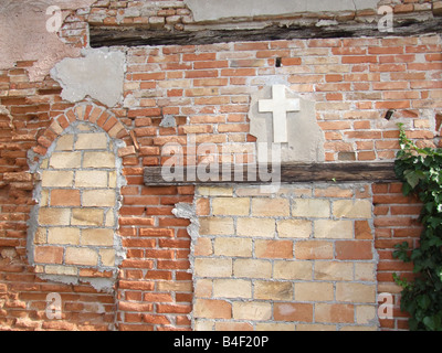 Vecchia chiesa abbandonati a parete con croce in Venezia Foto Stock