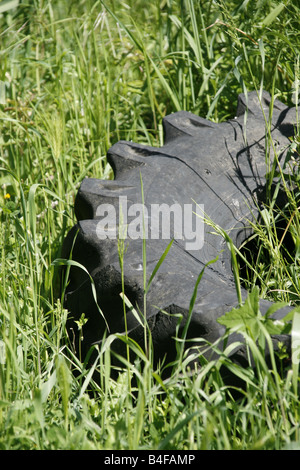 Vecchio trattore pneumatico abbandonato in erba lunga nel campo Foto Stock