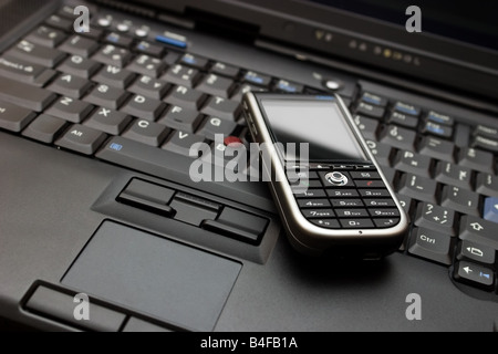 Tastiera del laptop fascia alta e moderna smartphone su di esso. Foto Stock