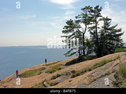 Escursionista e fotografo su di un'isola rocciosa nella Georgian Bay Ontario Foto Stock