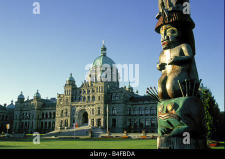 Una vista del Palazzo del Parlamento e un Indiano totem pole sul Porto Victoria, Victoria, British Columbia, Canada. Foto Stock