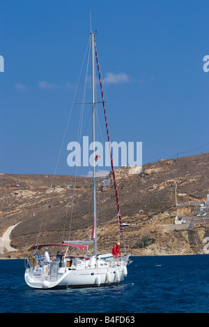 Un Oceanis 423 Clipper Yacht a vela lasciando Livadi città sull isola di Serifos Mare Egeo Cicladi Grecia Foto Stock