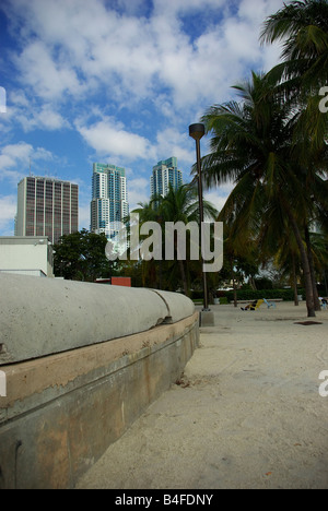 Una parete in cemento che separa la spiaggia sabbiosa dall'oceano in un parco nel centro cittadino di Miami, Florida Foto Stock