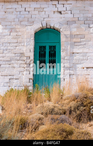 Un vecchio portone verde impostato nel muro bianco a Chora Serifos città isola di Serifos Cicladi Grecia Egeo Foto Stock