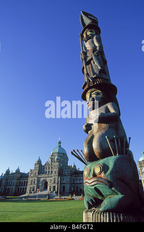 Una vista del Palazzo del Parlamento e un Indiano totem pole sul Porto Victoria, Victoria, British Columbia, Canada. Foto Stock