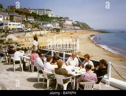 Regno Unito Inghilterra Isle of Wight Ventnor persone ristoranti sul lungomare nella luce del sole Foto Stock