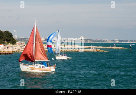 Barche a vela e dirigersi verso il porto di Poole con vedute di barene e Bournemouth in distanza Foto Stock