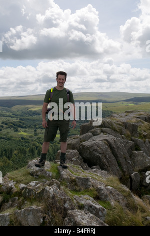 Un escursionista sulla parte superiore del cuoio Tor su Dartmoor guardando fuori su serbatoio Burrator Foto Stock