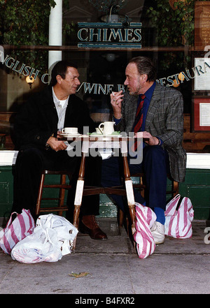 Don Henderson attore Michael Elphick attore seduti al cafe' sul marciapiede tabella con le borse della spesa a parlare e fumare una sigaretta Foto Stock