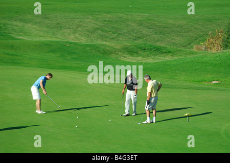 Tre giocatori di golf di competere sui verdi campi da golf - Francia Foto Stock