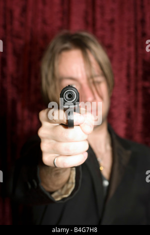 Un uomo che ha di mira una pistola Foto Stock