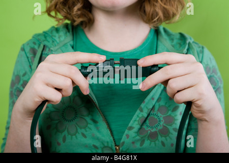 Una giovane donna entra a far parte di un connettore elettrico per un cavo di prolunga Foto Stock