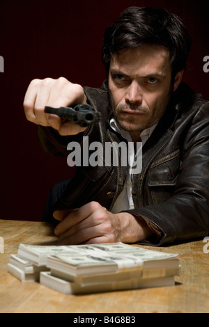 Un uomo in possesso di una pistola minacciosamente Foto Stock