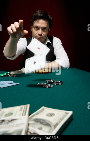 Un uomo gettando due schede ace a high stakes poker game Foto Stock