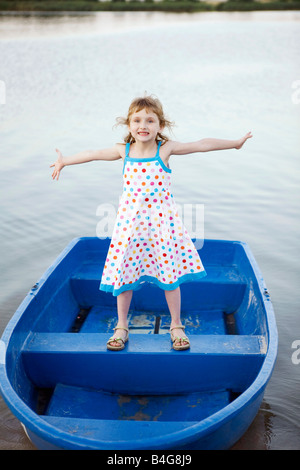 Una giovane ragazza in piedi su una barca Foto Stock