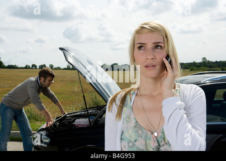 Un paio di piedi al bordo della strada accanto a loro ripartiti in auto Foto Stock