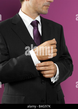 Un uomo del suo fissaggio cufflink Foto Stock