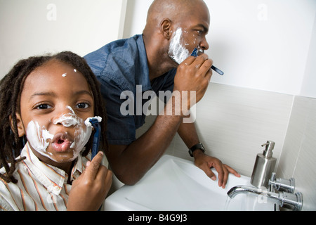 Un figlio imitando il suo padre la rasatura Foto Stock