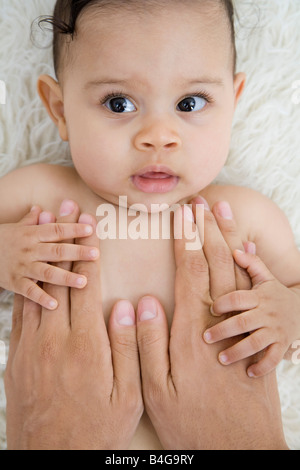 Le mani umane consolante un bambino Foto Stock
