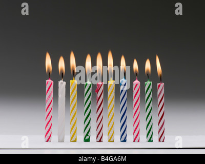 Una fila di masterizzazione multi colore candele di compleanno Foto Stock
