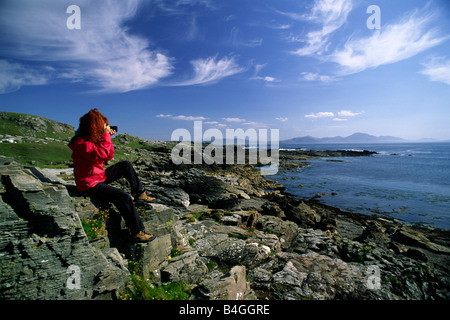 Irlanda, Contea di Donegal, Malin Head, il punto più settentrionale dell'Irlanda, ragazza che scatta foto Foto Stock