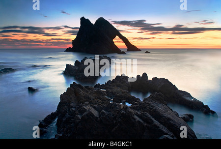 Arco di roccia di violino presso sunrise vicino Portknockie, murene, Scozia Foto Stock