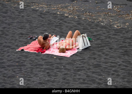 Azzorre San Miguel .un paio di prendere un bagno di sole sul nero vulkano sabbia con Mosteiros Foto Stock