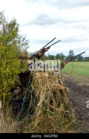 Gli adolescenti vestito in Abbigliamento camouflage 12 tiro fucili calibro  da un cieco di anatra Foto stock - Alamy