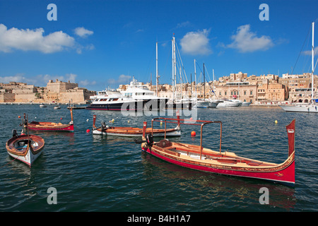 Vecchio e nuovo, tradizionale e moderno: dghasja ed oceaniche yachts, Malta Foto Stock