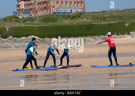 Il gruppo di amici nella scuola di surf di ottenere istruzioni da un istruttore su fistral beach newquay cornwall Foto Stock