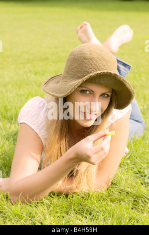 Ritratto di donna sdraiata su erba e sorridente Foto Stock