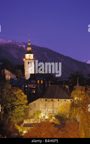 Chiesa illuminata di fronte montagne di Albertville, sulle Alpi francesi, Francia Foto Stock