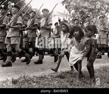 Soldati britannici marciando in Georgetown Guyana Britannica seguita da alcuni bambini nel 1953 1953 la Costituzione Waddington è sospesa su dicembre 22 il Royal Welsh Fusiliers sono spediti in Guyana per il controllo di un qualsiasi focolaio di violenza che possono seguire la sospensione la casa di montaggio si sciolse tutti Foto Stock