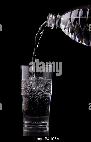 Close-up di acqua versata nel bicchiere da acqua Foto Stock