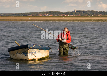 Pescatore che raccoglie le cozze a Blakeney Harbour Norfolk Foto Stock