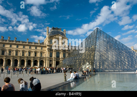 I turisti coda presso la piramide in ingresso al Musée du Louvre, Parigi Foto Stock