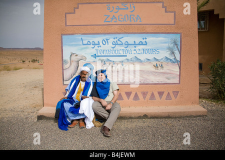 I turisti dal cartello stradale di Tombouctou 52 Jours attraverso il deserto da cammello Timbuctù 52 giorni Zagora Marocco.orizzontale.89922 Marocco Foto Stock