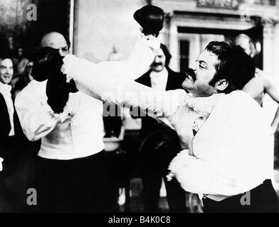 Oliver Reed attore come Bismark e Henry Cooper boxer Gennaio 1975 In una scena da film Flash reale di essere colpito da due strade Productions a Twickenham Middlesex Foto Stock