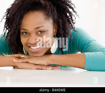 Donna Africana appoggiata mento sulle mani Foto Stock