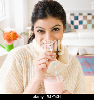 Razza mista donna bere il frullato Foto Stock