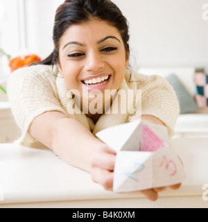Razza mista donna holding origami fortune teller Foto Stock