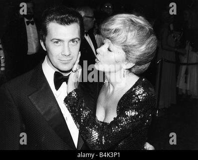 Lewis Collins attore ha la sua faccia accarezzata da Ingrid Pitt alla premiere del suo film chi osa vince Agosto 1982 Dbase Foto Stock