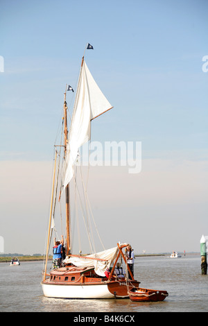 Una famiglia alzare le vele sulla loro barca come si preparano a navigare il Fiume y vengono vicino a Yarmouth su Norfolk Broads Foto Stock