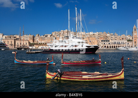 Vecchio e nuovo, tradizionale e moderno: dghasja ed oceaniche yachts, Malta Foto Stock