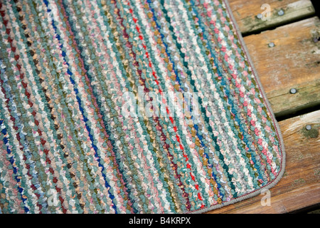 Un piccolo buttare rug su un ponte di legno. Foto Stock