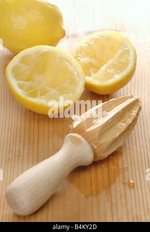Alcuni limoni freschi con una mano tenuta centrifuga Foto Stock