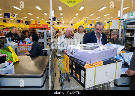 Shoppers coda presso il check out di un supermercato di bilancio nel Regno Unito Foto Stock