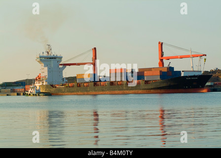 Il contenitore nave oceano Clou Docking a Lavrio Porto sulla terraferma greca in inizio di mattina di sole Foto Stock